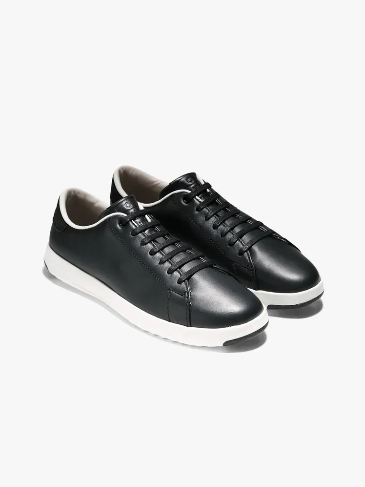 รองเท้าผ้าใบเทนนิส Cole Haan GrandProø ในส่วนประกอบที่มีแบรนด์บนพื้นหลังสีเทาอ่อน