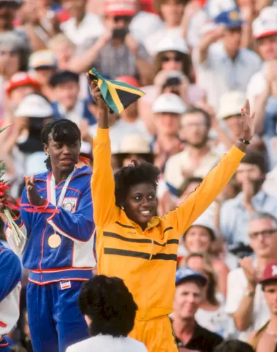 ربما تحتوي الصورة على ملابس Merlene Ottey، قبعة، إكسسوارات شخص الطفل، نظارات، رأس، وجه، احتفال وسعيد