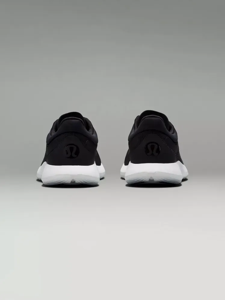 Sepatu Pelatihan Strongfeel dengan warna hitam dan putih bermerek dengan latar belakang abu-abu gelap