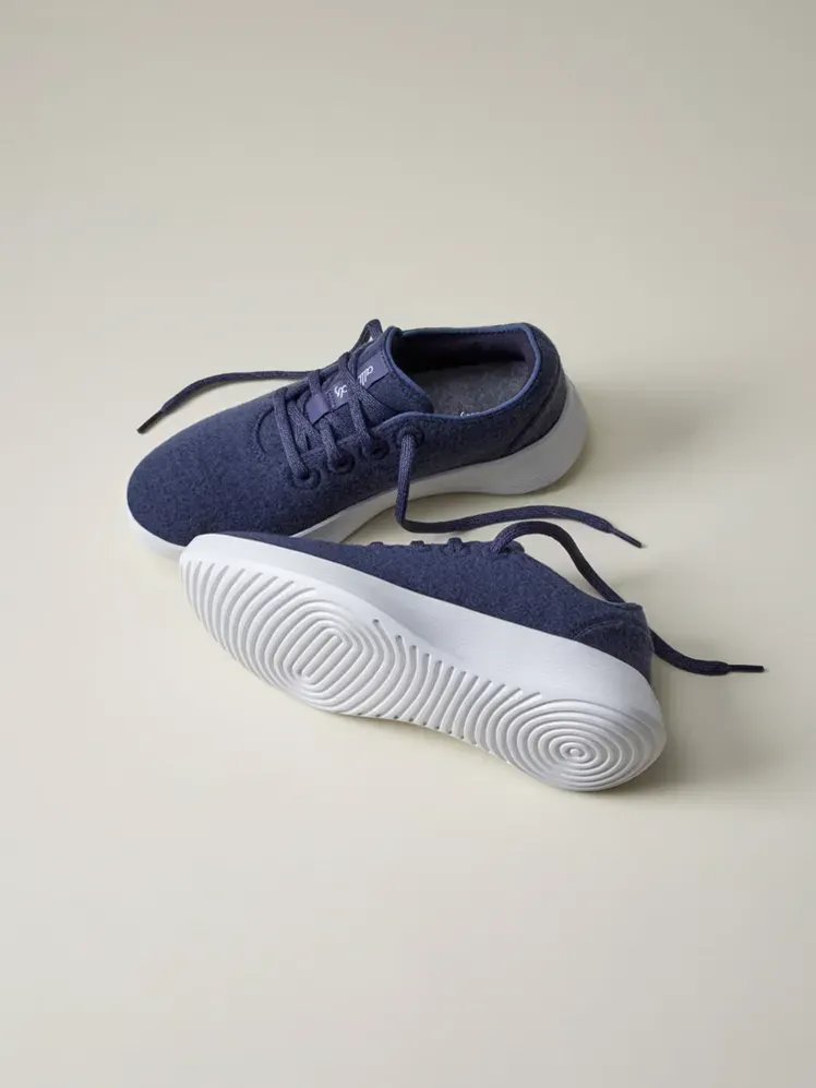 Wool Runner Go dengan warna biru dan putih bermerek dengan latar belakang krem