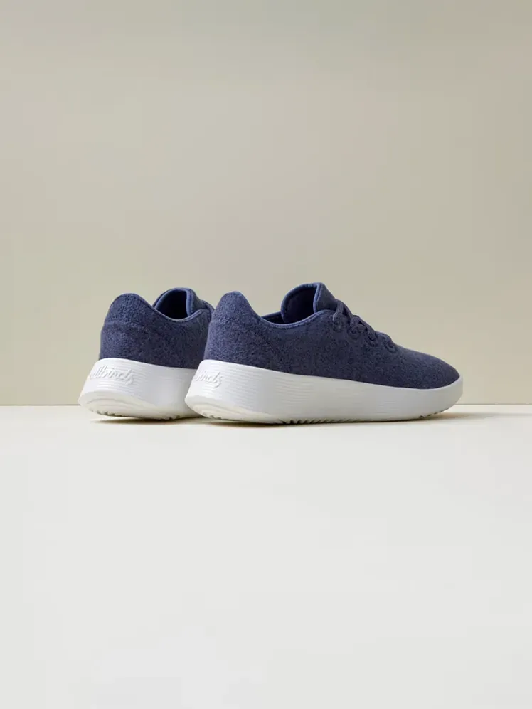 Wool Runner Go dengan warna biru dan putih bermerek dengan latar belakang krem