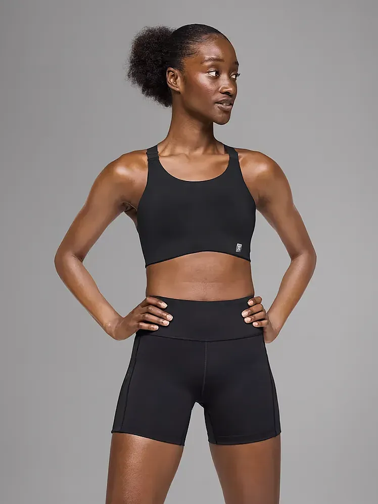 灰色の背景のモデルにブランドの黒い色のエンデュランス ブラ