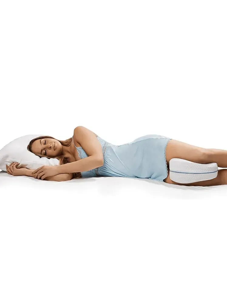 Legacy Leg Pillow біло-блакитного кольору, який використовується моделлю на ліжку