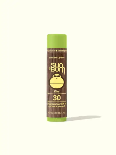 Sun Bum Original Sunscreen Lip Balm SPF 30 i merkede brune og gule twist up tube på lysegrønn bakgrunn