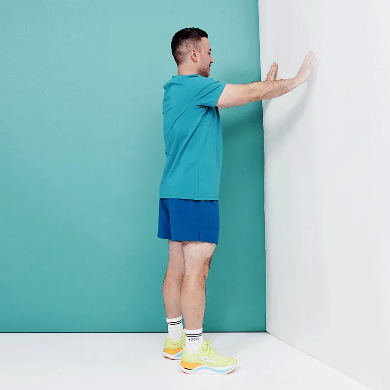 Встаньте прямо обличчям до стіни, ноги розставте на відстані боків. Покладіть обидві долоні на руки на стіні на висоті плечей і...