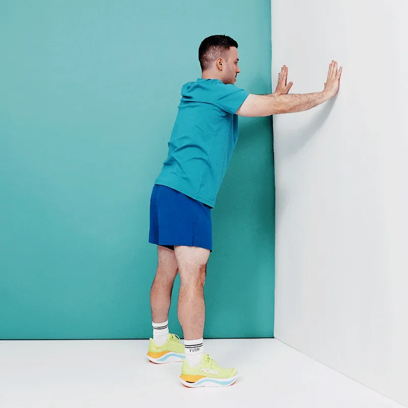 Прийміть широку позицію перед стіною, злегка зігнувши коліна. Покладіть обидві долоні на стіну на кілька дюймів вище...