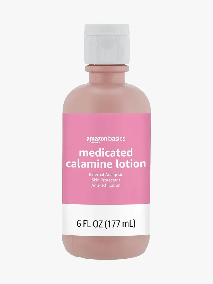 Lozione anti-prurito alla calamina medicata Amazon Basics nel componente di marca su uno sfondo grigio chiaro