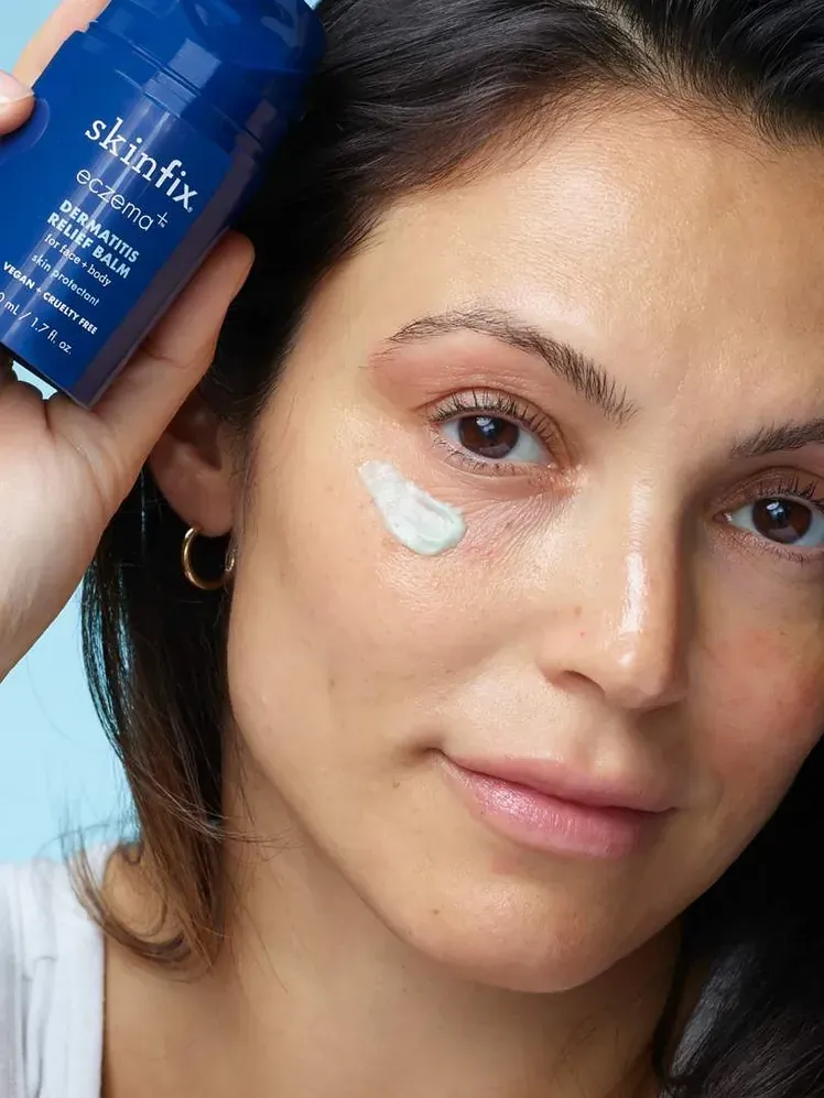 Modell által tartott ekcéma+ dermatitisz enyhítő balzsam termékmintával az arcon