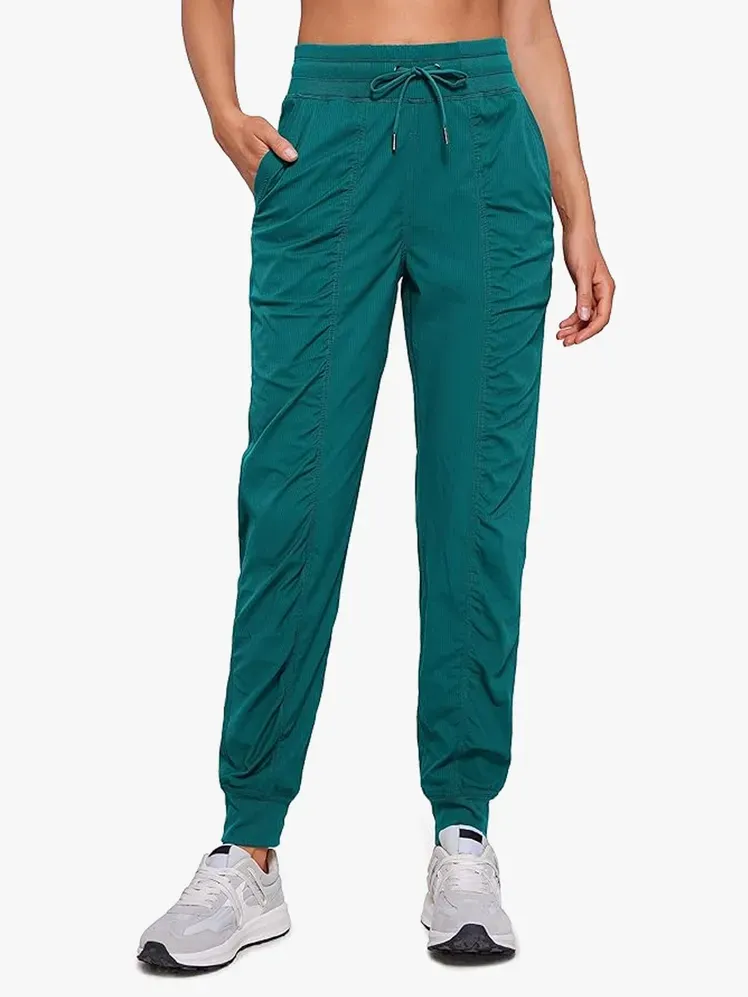 Lette treningsjoggere i fet grønn farge på modell på lys grå bakgrunn