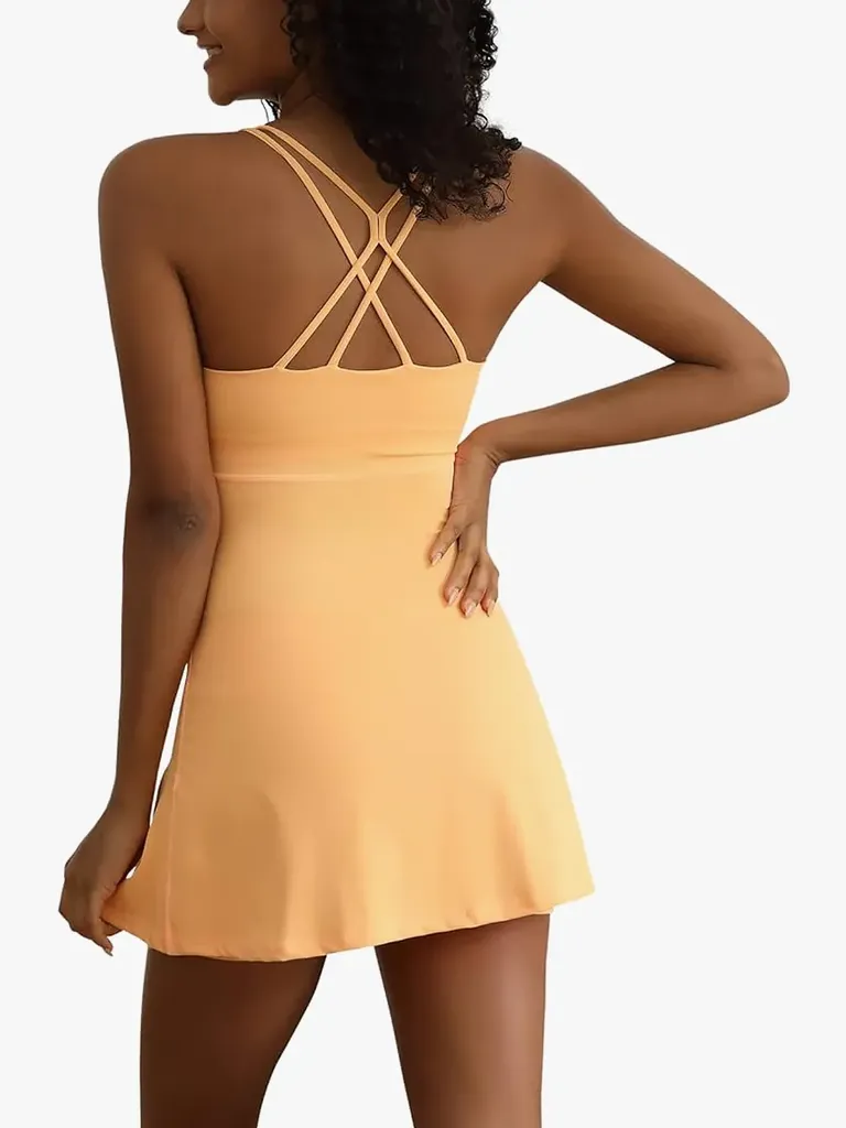 Tenniskjole for trening i myk gul farge på modell på lys grå bakgrunn