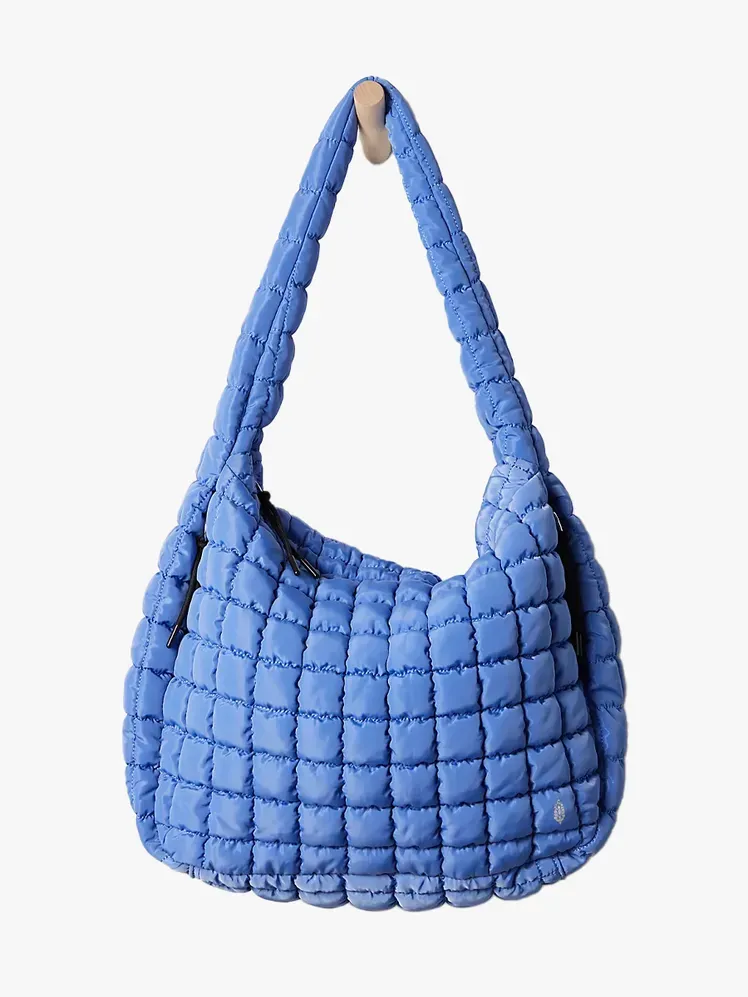 Стьобана сумка Free People у фірмовому складі на світло-сірому фоні