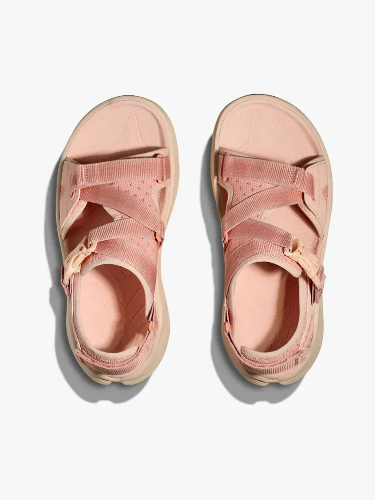 Açık gri arka plan üzerinde markalı bileşenli Hoka Infini Hike TC