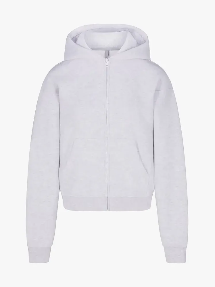 Klassisk hættetrøje med lynlås i bomuldsfleece i grå farve på lysegrå baggrund
