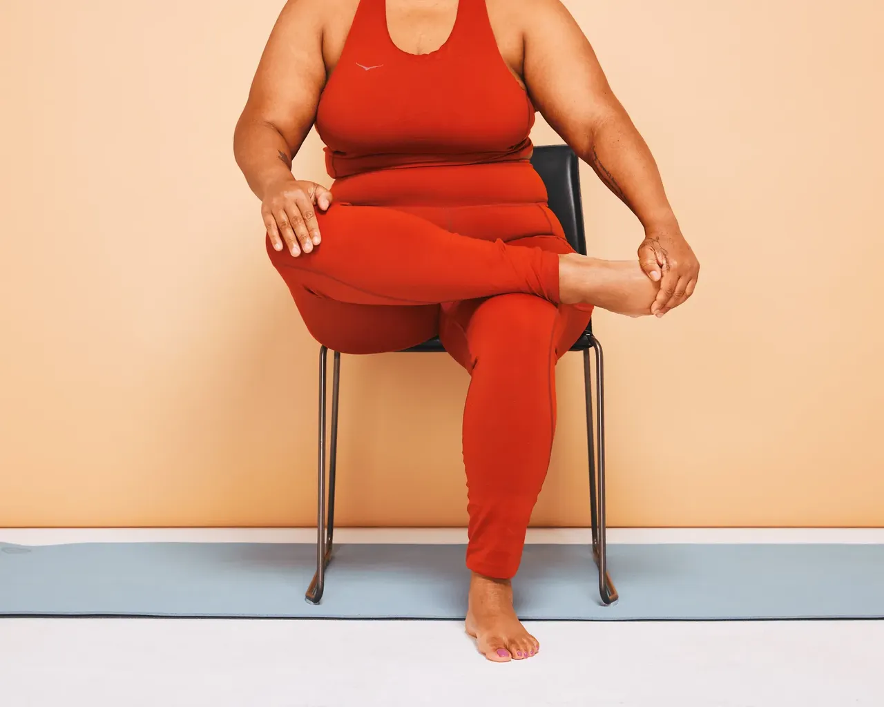 باريس تؤدي تمرين تمدد قصبة الكرسي جالسًا