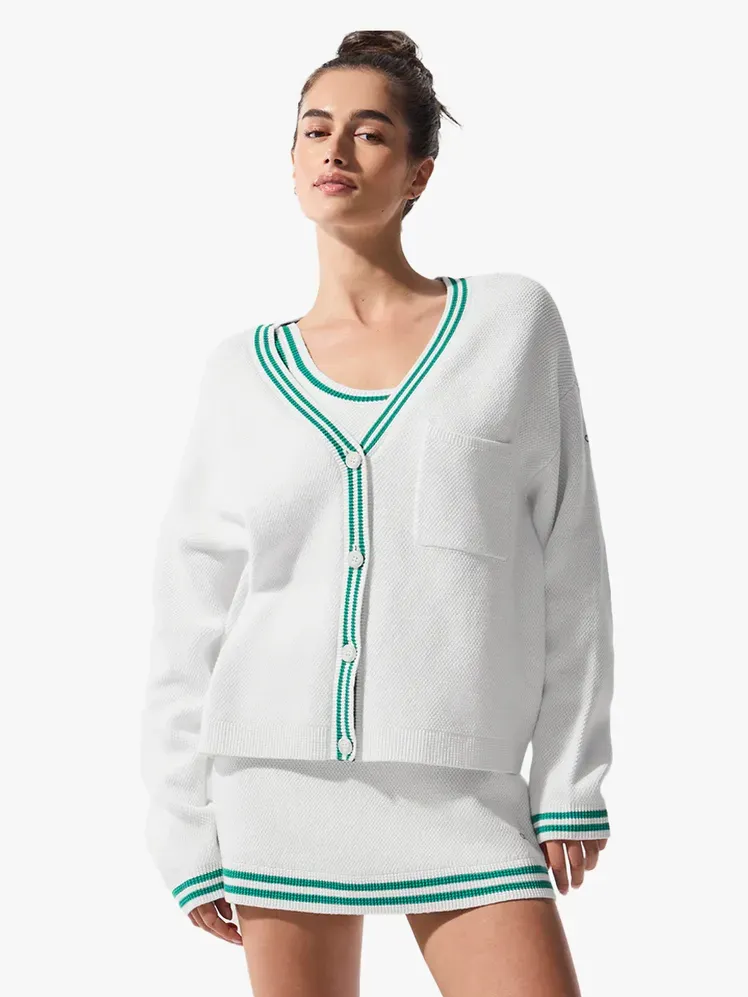 Alo Yoga Tenis Kulübü Kazak Örgü Hırka, açık gri arka plan üzerinde markalı bileşen