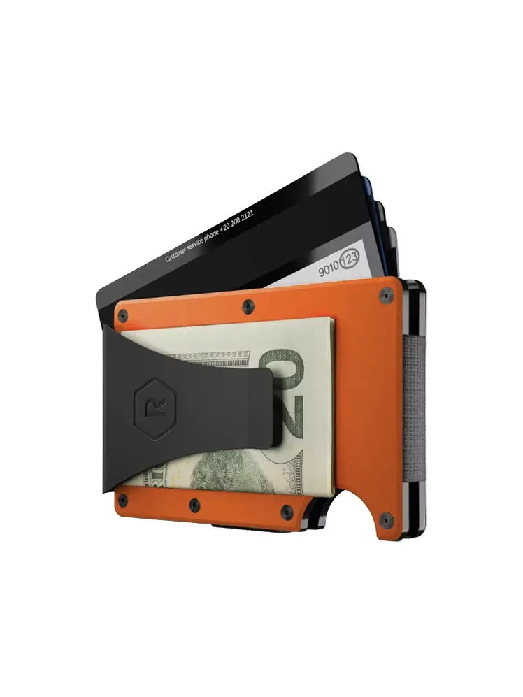 Ridge Aluminium-Geldbörse + Geldklammer in den Farben Orange und Schwarz mit Geld und Kreditkarten auf weißem Hintergrund