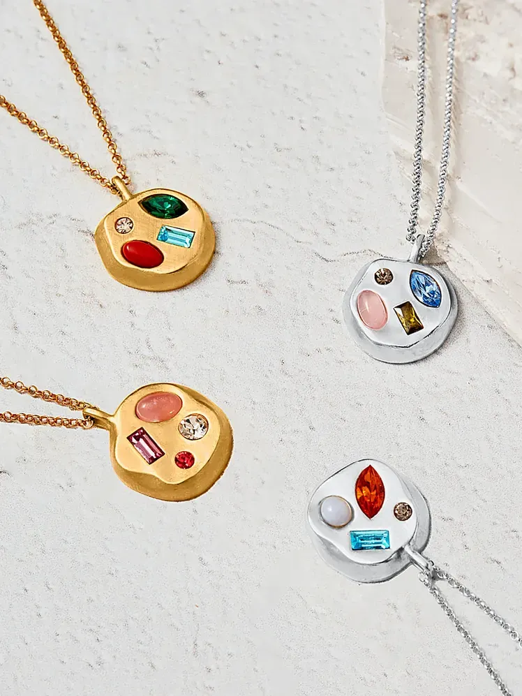 El collar con colgante de cumpleaños en varias combinaciones de colores sobre fondo con textura gris