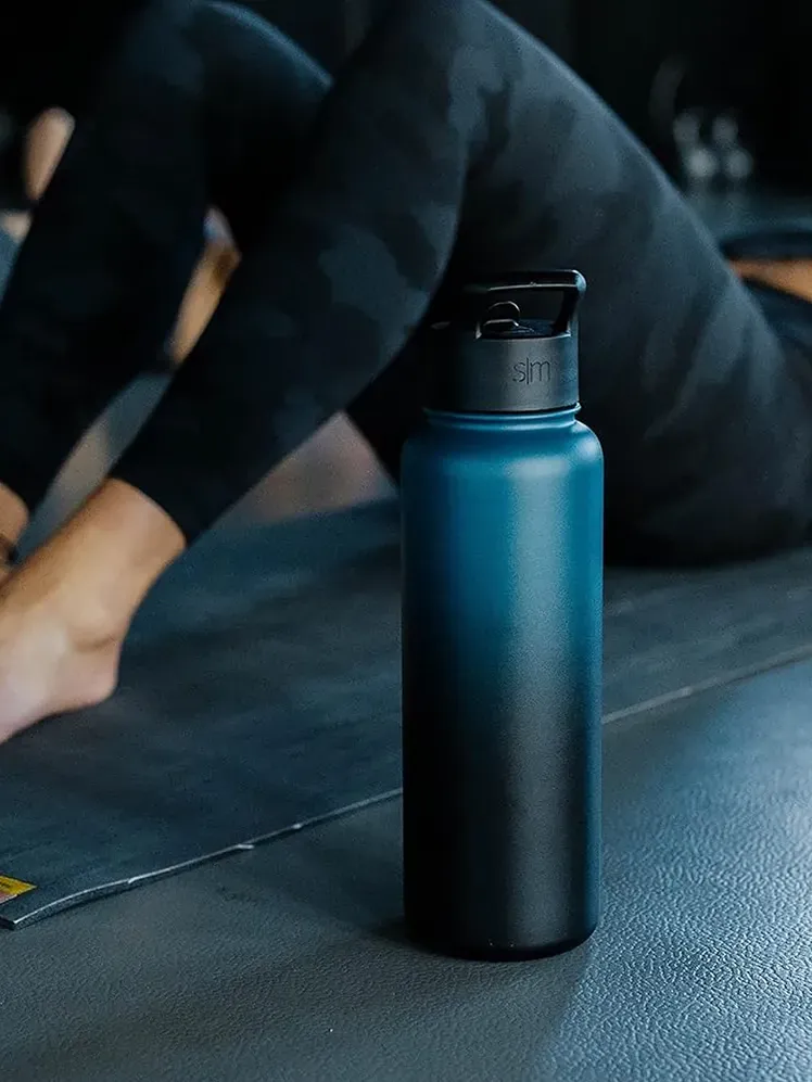 ขวดน้ำสีฟ้าไล่ระดับข้างนางแบบออกกำลังกาย