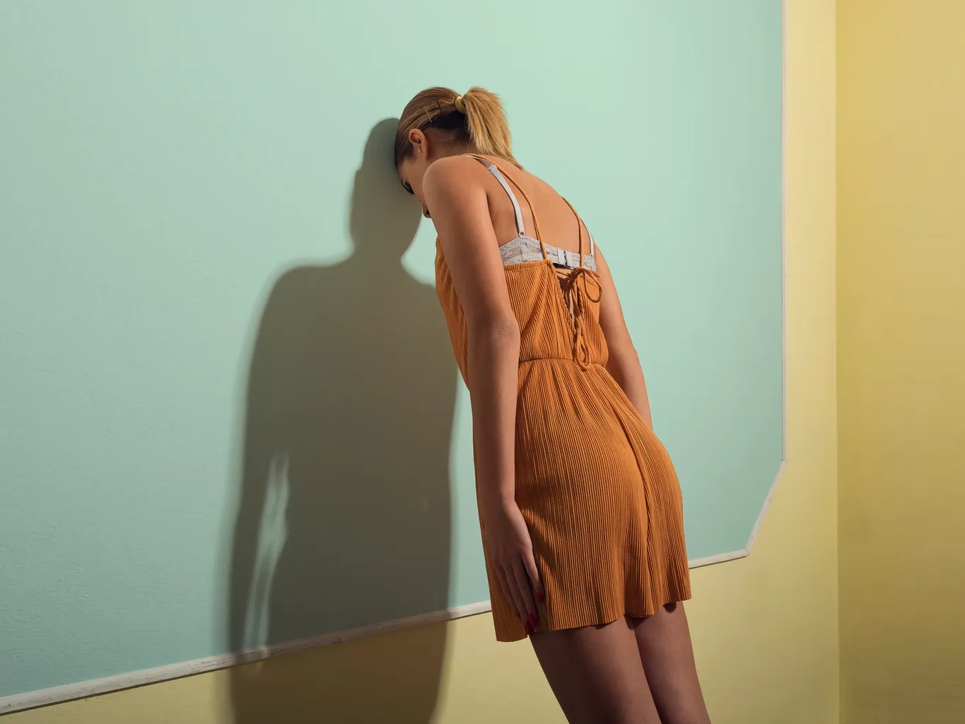 ਔਰਤ ਆਪਣਾ ਸਿਰ ਕੰਧ ਨਾਲ ਝੁਕਾ ਰਹੀ ਹੈ