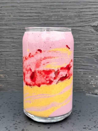 ਇੱਕ ਸਲੇਟੀ ਬੈਕਗ੍ਰਾਊਂਡ ਵਿੱਚ ਇੱਕ ਸਾਫ਼ ਸ਼ੀਸ਼ੇ ਵਿੱਚ ਪੀਬੀਜੇ ਸਮੂਦੀ