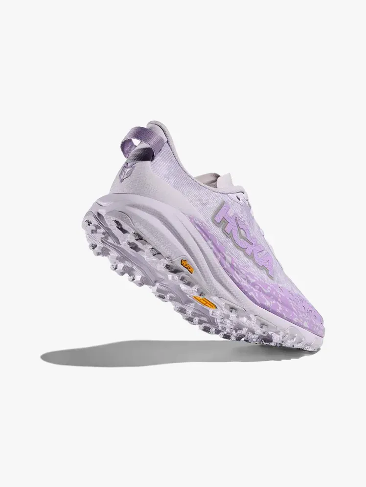 Hoka Speedgoat 6 مكون ذو علامة تجارية على خلفية رمادية فاتحة