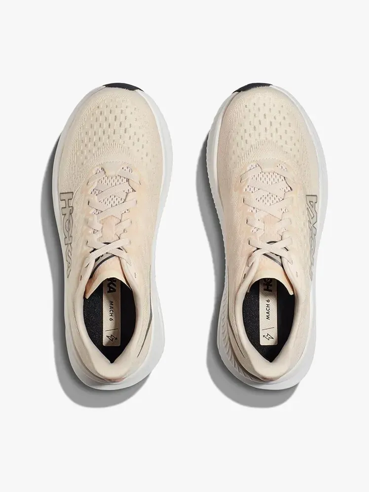 Hoka Mach 6 في مكون ذو علامة تجارية على خلفية رمادية فاتحة