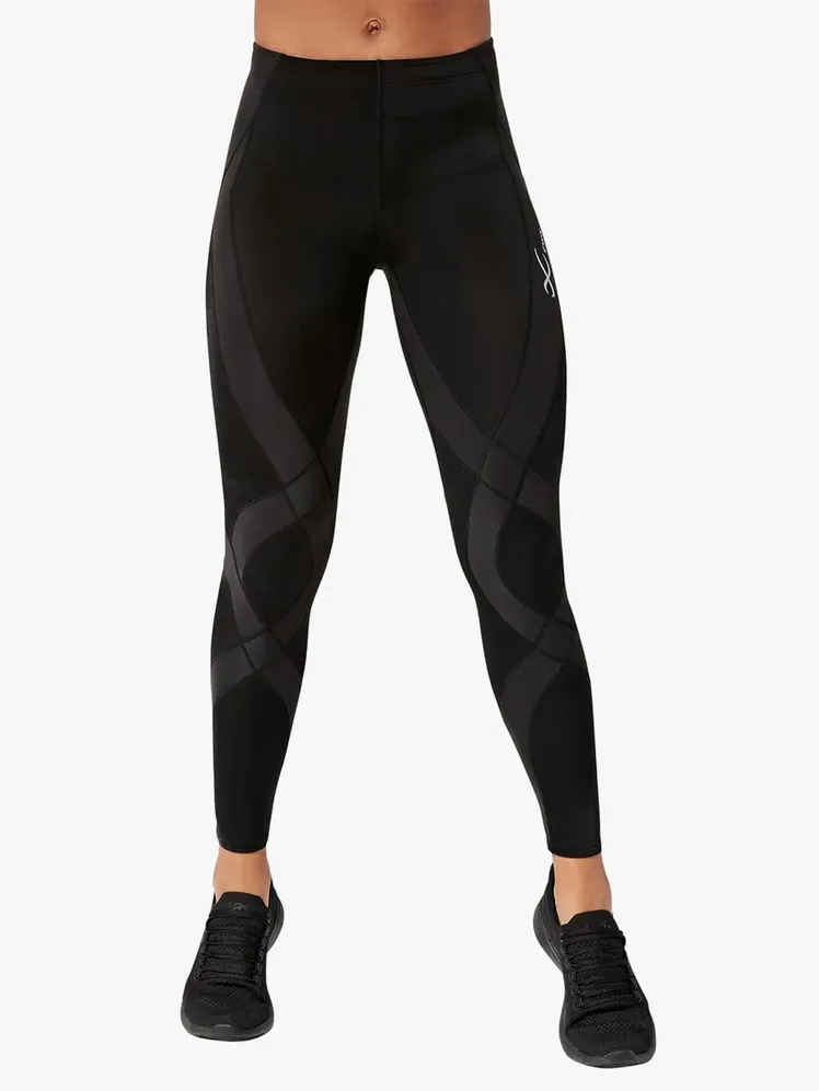 हल्के भूरे रंग की पृष्ठभूमि पर मॉडल पर काले और भूरे रंग में एंड्योरेंस जेनरेटर लेगिंग्स