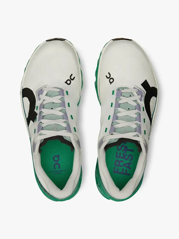 Cloudmonster Hyper dalam warna putih hitam dan hijau bermerek dengan latar belakang abu-abu terang