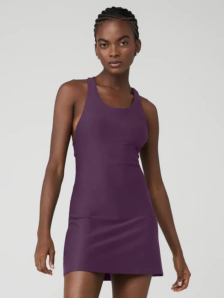 Airlift Fly Dress dengan warna ungu tebal pada model dengan latar belakang abu-abu