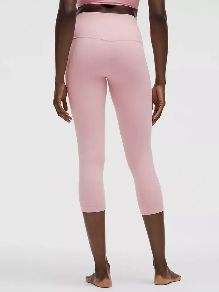 Sejajarkan High-Rise Crop 23 dengan warna merah muda lembut bermerek pada model dengan latar belakang abu-abu