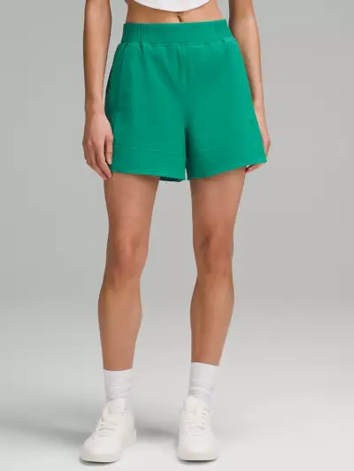 Lululemon Stretch Woven Relaxed-Fit High-Rise Short in weicher Meeresschaumgrünfarbe am Modell vor grauem Hintergrund