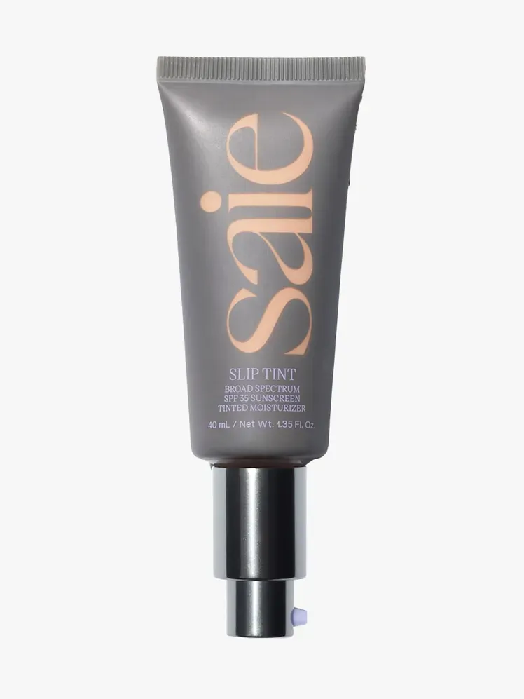 Saie Slip Tint Dewy Tinted Moisturizer SPF 35 ve značkovém tubusovém komponentu na světle šedém pozadí