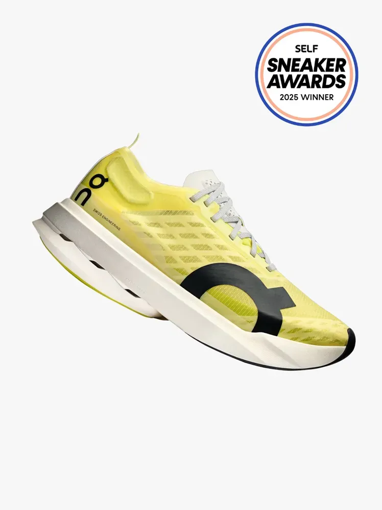 Он Цлоудбоом Стрике жуте патике на светлосивој позадини са печатом СЕЛФ Снеакер Авардс у горњем десном углу