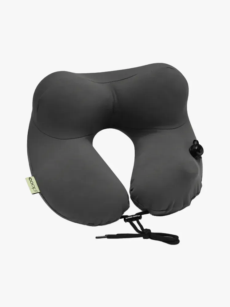 Coop AirJustable Travel Neck Pillow dalam komponen bermerek dengan latar belakang abu-abu terang